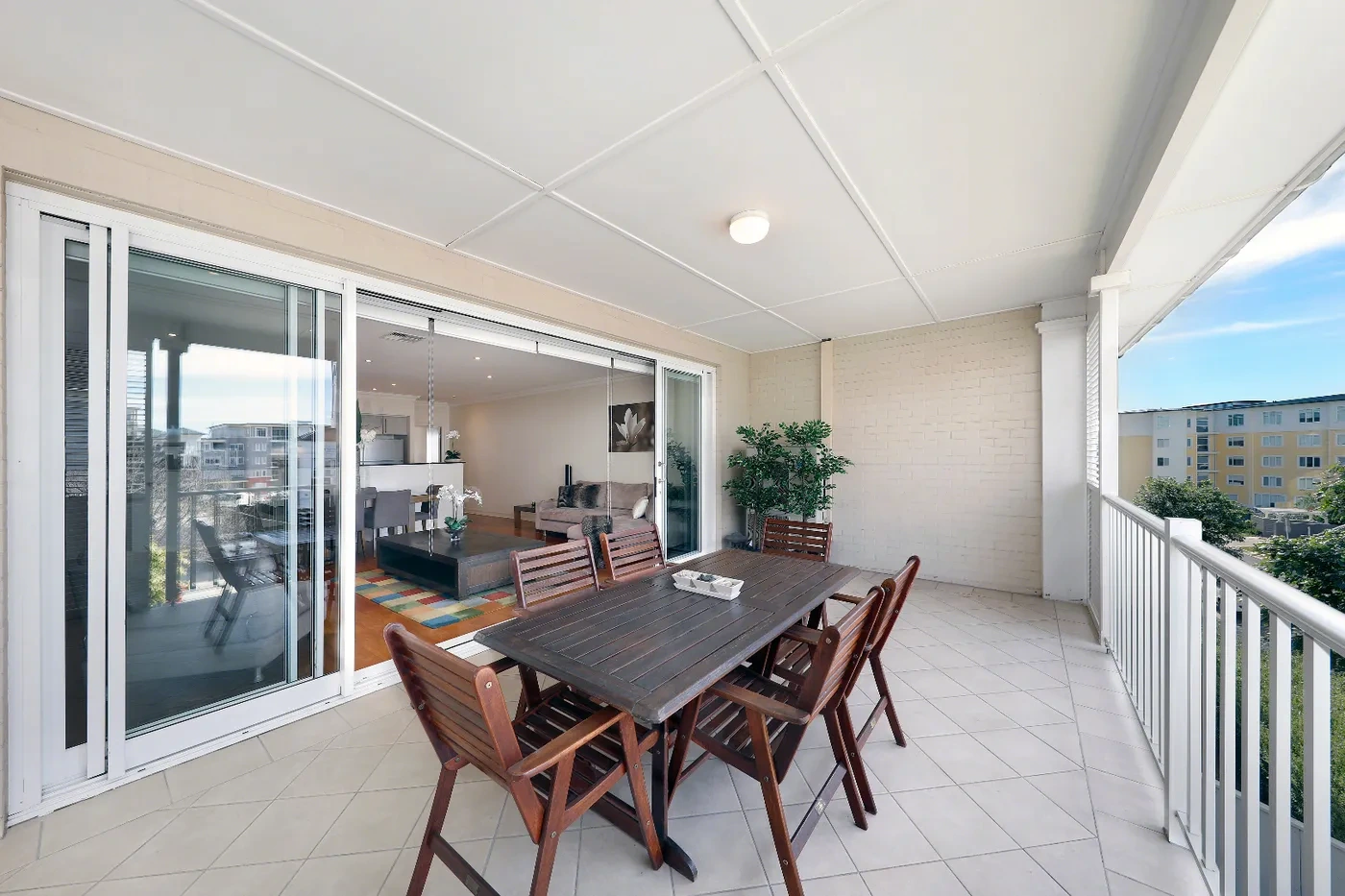 Dining and living opening to the balcony at a Westprecinct serviced residence in Breakfast Point