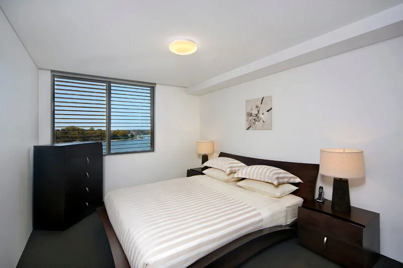 Furnished master bedroom with water outlook