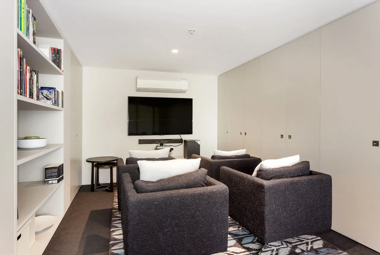 Residents’ lounge with armchairs and bookshelves at a Westprecinct serviced residence in Malvern