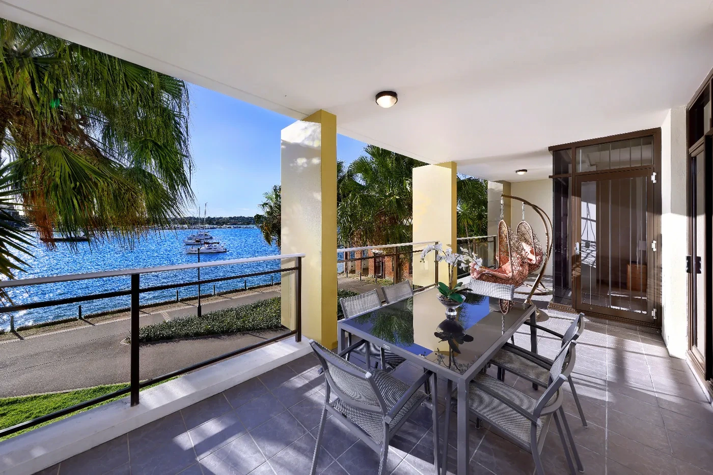 Covered balcony with outdoor dining and harbour glimpses at a Westprecinct serviced residence in Rozelle